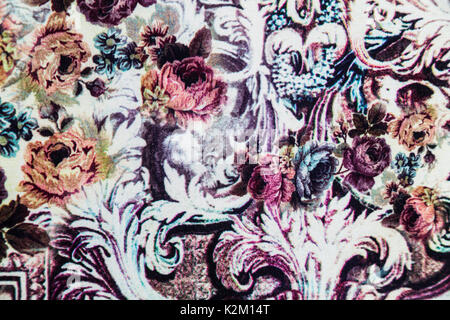 Knitwear fabric with elastane with floral abstract pattern of pink, orange, purple scarlet roses with leaves. Stock Photo