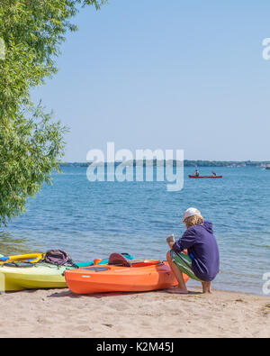 Colourful kayaks for rent at Couchiching Beach in Orillia Ontario Canada. Stock Photo