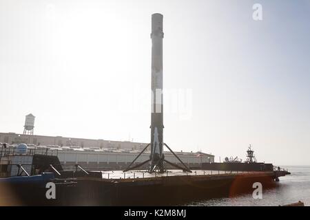 The SpaceX Falcon 9 rocket first stage booster arrives at the Port of Long Beach on a floating drone ship August 28, 2017 in Long Beach, California. The rocket successfully carried a Taiwanese satellite into orbit and returned to land on the drone ship on August 24th. Stock Photo