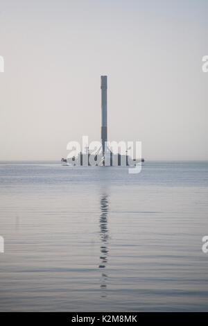 The SpaceX Falcon 9 rocket first stage booster arrives at the Port of Long Beach on a floating drone ship August 28, 2017 in Long Beach, California. The rocket successfully carried a Taiwanese satellite into orbit and returned to land on the drone ship on August 24th. Stock Photo