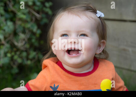 Happy 10 month old baby girl clapping Stock Photo