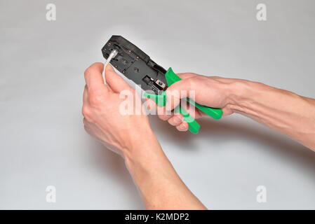 Hands of the installer of computer networks ticks crimped connec Stock Photo