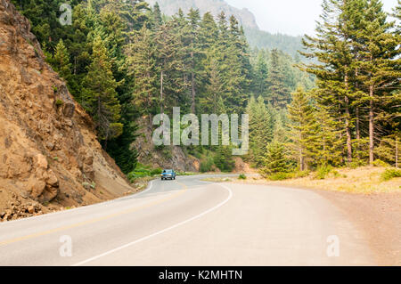 A car climbing Hurricane Ridge Road on the Olympic Peninsula with haze from forest fires across border in Canada. Stock Photo