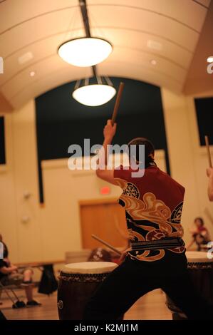 Playing Japanese taiko drums inside building Stock Photo