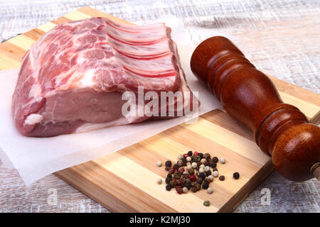 Raw pork chops and spice grinder on cutting board. Ready for cooking Stock Photo