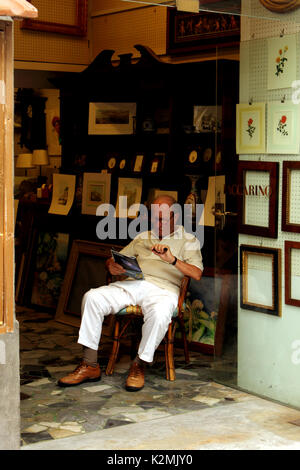 Upright view of man reading in book shop Sorrento Amalfi Coast Italy Stock Photo
