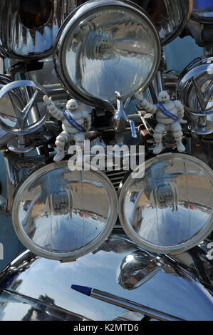 the array of headlights and lamps in chrome and silver reflective on the front of a vespa or lamberetta scooter at a scooter rally isle of wight Stock Photo