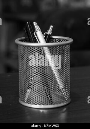 Three stylish pens in a basket on a table in black and white. Stock Photo