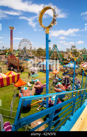 An amusement park in Costa Mesa, CA, includes mechanical bears, a Ferris wheel, Vertigo ride and tents for attractions. Stock Photo