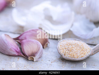 selective focus showing an atmospheric horizontal image of garlic salt and cloves on an authentic old wooden table light blurred background to aid cop Stock Photo