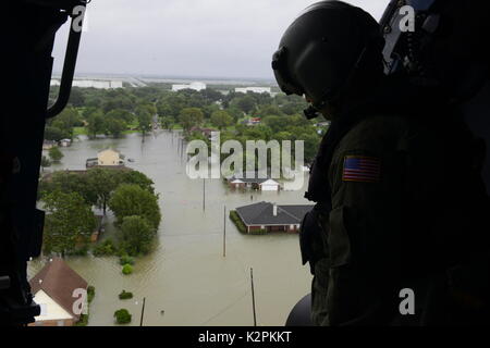 Beaumont, United States. 30th Aug, 2017. U.S. Coast Guard aircrew personnel look out at flood neighborhoods as they respond to an emergency evacuation by helicopter in the aftermath of Hurricane Harvey August 30, 2017 in Beaumont, Texas. Credit: Planetpix/Alamy Live News Stock Photo