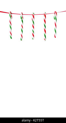 Five red and green striped candy canes hanging on a red ribbon as Christmas background. Stock Photo