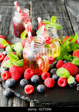 berry juice in a glass with berries, ice and mint, selective focus Stock Photo