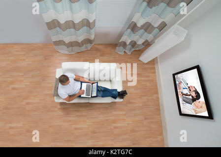 High Angle View Of Young Man Working On Laptop At Home Stock Photo