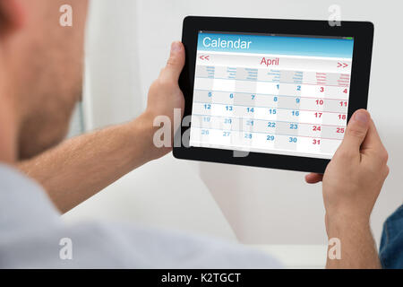 Close-up Of Person Holding Digital Tablet Showing Calendar Stock Photo