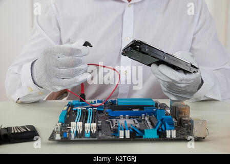 Close-up Of Male Technician With Motherboard And Harddisk Stock Photo