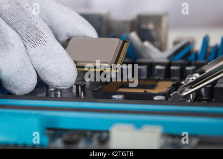 Close-up Of Person Hands Installing Central Processor In Motherboard Stock Photo