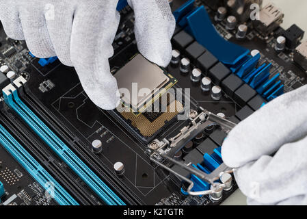 Close-up Of Person Hands Installing Central Processor In Motherboard Stock Photo