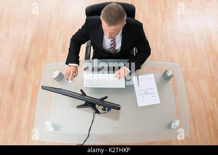 Young Businessman Working On Computer At Desk Stock Photo