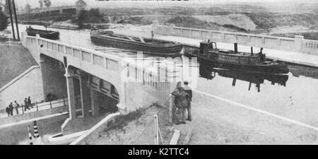 1930's - A photograph of barges on the  Grand Junction Canal as it passes over the viaduct oftow the North Circular Road, London, just after its construction. One barge is marked Marylebone Borough Council Stock Photo