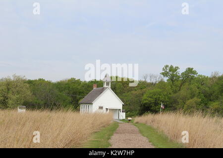 Old one room school house at the end of a path surrounded by Kansas prairie. Stock Photo