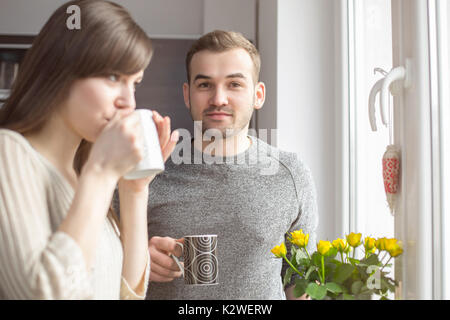 Young couple having morning coffee in kitchen Stock Photo