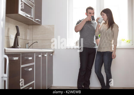 Young couple having morning coffee in kitchen Stock Photo