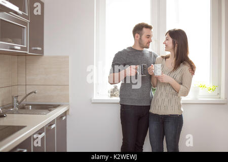 Young couple having coffee in kitchen Stock Photo