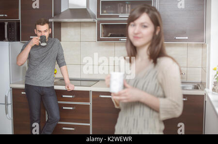 Cheerful husband in kitchen with his wife on a foreground Stock Photo