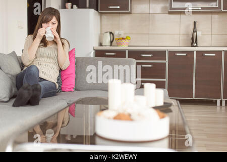 Woman on sofa having afternoon coffee Stock Photo