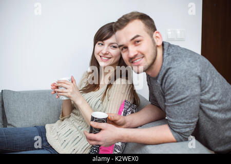 Smiling couple having coffee in living room Stock Photo