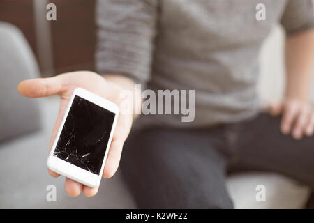 Man showing destroyed white smart phone Stock Photo