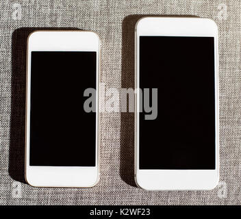 Comparison of two white smart phones Stock Photo