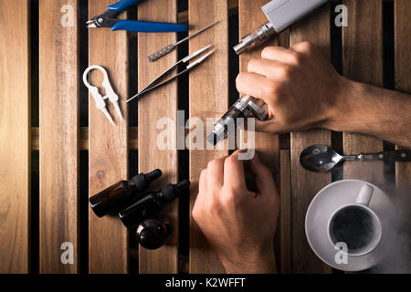 user holding by hands an electronic cigarette, vaping device top view,  overhead view of e cigarette, e liquid, vape tools Stock Photo - Alamy