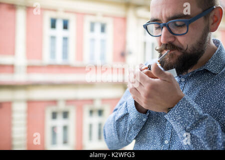 Fashion man lighting up joint. Stock Photo