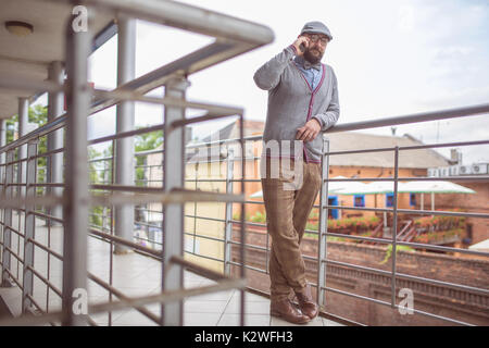 Man wearing stylish clother talking on the phone at terrace Stock Photo