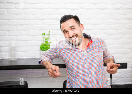 Happy man in casual shirt pointing his fingers at camera Stock Photo