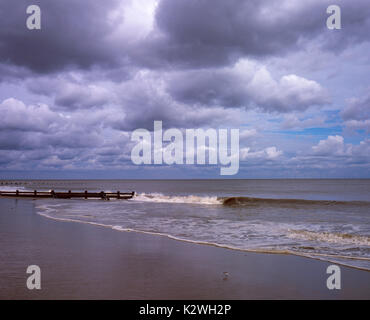 Clouds clearing the beach with wind farm in the background Skegness Lincolnshire England Stock Photo