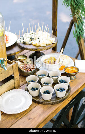 growing, meal, table setting concept. delicious wonderful treat for guests for all tastes, there are blueberries in the paper cups, rolls and sushi, n Stock Photo