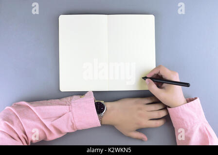 Hands writing in the note book. Flat lay style. Stock Photo