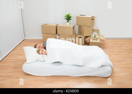 Young Couple Sleeping On Mattress In New Home Stock Photo