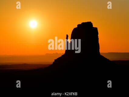 Monument Valley Arizona Perfect Sunrise - East Mitten Butte Silhouette Dawn Sunrise Sunset Mist Fog  The Mittens. Stock Photo