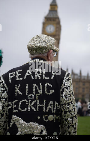 Pearly King, Queen and Prince of Peckham, in their Pearly Kings clothes, outside Houses of Parliament and Big Ben, London, England, UK. Stock Photo