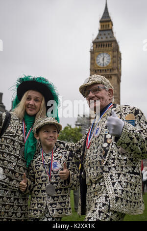 Pearly King, Queen and Prince of Peckham, in their Pearly Kings clothes, outside Houses of Parliament and Big Ben, London, England, UK. Stock Photo