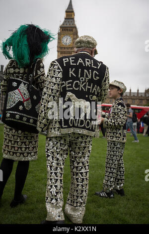 Pearly King, Queen and Prince of Peckham, in their Pearly Kings clothes, outside Houses of Parliament and Big Ben, London, England, UK. Stock Photo