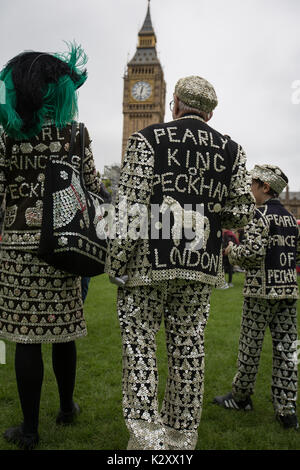 Pearly King, Queen and Prince of Peckham, in their Pearly Kings clothes, outside Houses of Parliament and Big Ben, London, England, UK. Stock Photo