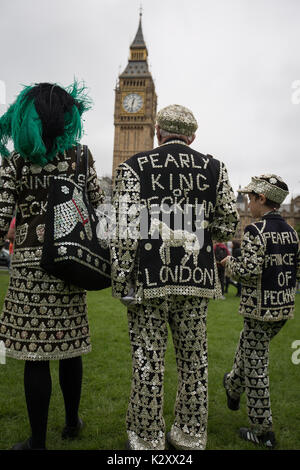 Pearly King, Queen and Prince of Peckham, in their Pearly Kings clothes, outside Houses of Parliament and Big Ben, London, England, UK. Stock Photo