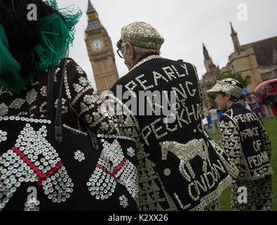 Pearly King, Queen and Prince of Peckham, in their Pearly Kings clothes, outside Houses of Parliament and Big Ben, London, England, UK. Stock Photo