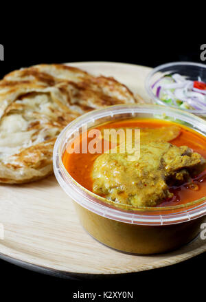 red curry chicken serve with roti and sour sauce on black background Stock Photo