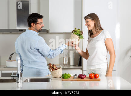 playful couple preparing food in a kitchen Stock Photo